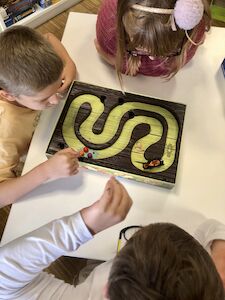 Ansicht von oben, wie drei Kinder ein Spiel spielen.