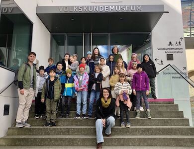 Die Sonnen-Klasse posiert als Gruppe vor dem Eingang des Volkskundemuseums.