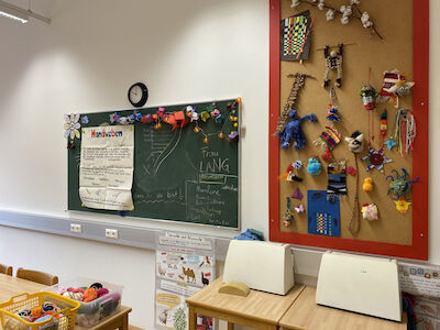 Ansicht der Tafel un Korkwand, die dem neuen Wandverbau gegenüber liegen. Auf zwei Tischen stehen auch Nähmaschinen.