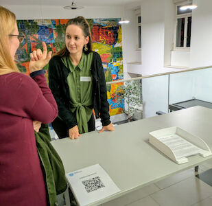 Eine Lehrerin tauscht sich mit einem Elternteil über organisatorische Dinge aus.