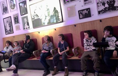 Sechs Kinder sitzen auf gemütlichen Sitzen im