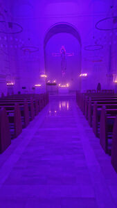 Stimmungsvolle Atmosphäre in der Kirche des Augustinums ohne Menschen und vielen brennenden Kerzen (Hochformat).