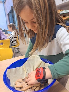 Ein Bub nimmt Lebkuchen aus einer Schüssel.