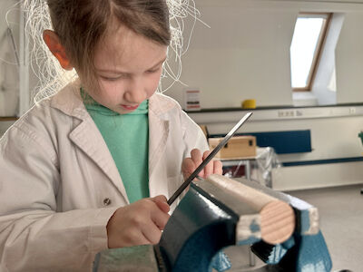 Ein Mädchen feilt den selbstgemachten Schraubendreher.