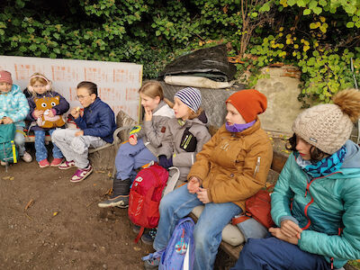 Ein Teil der Bären-Klasse sitzt und jausnet im Freien.