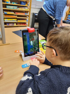 Ein Bub arbeitet am iPad OSMO Coding Awbie