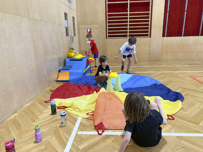 Eine Bubengruppe baut gerade an einer Hütte, wo auch das Fallschirmtuch Verwendung findet.