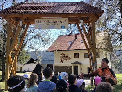 Beim BIO-Bauernhof "Fam. Smolana" bekommen die Kinder von einem Mann wichtige Dinge erklärt.