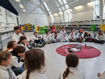 Die Kinder der Bären-Klasse werden im Kreis auf den Stationenbetrieb vorbereitet.
