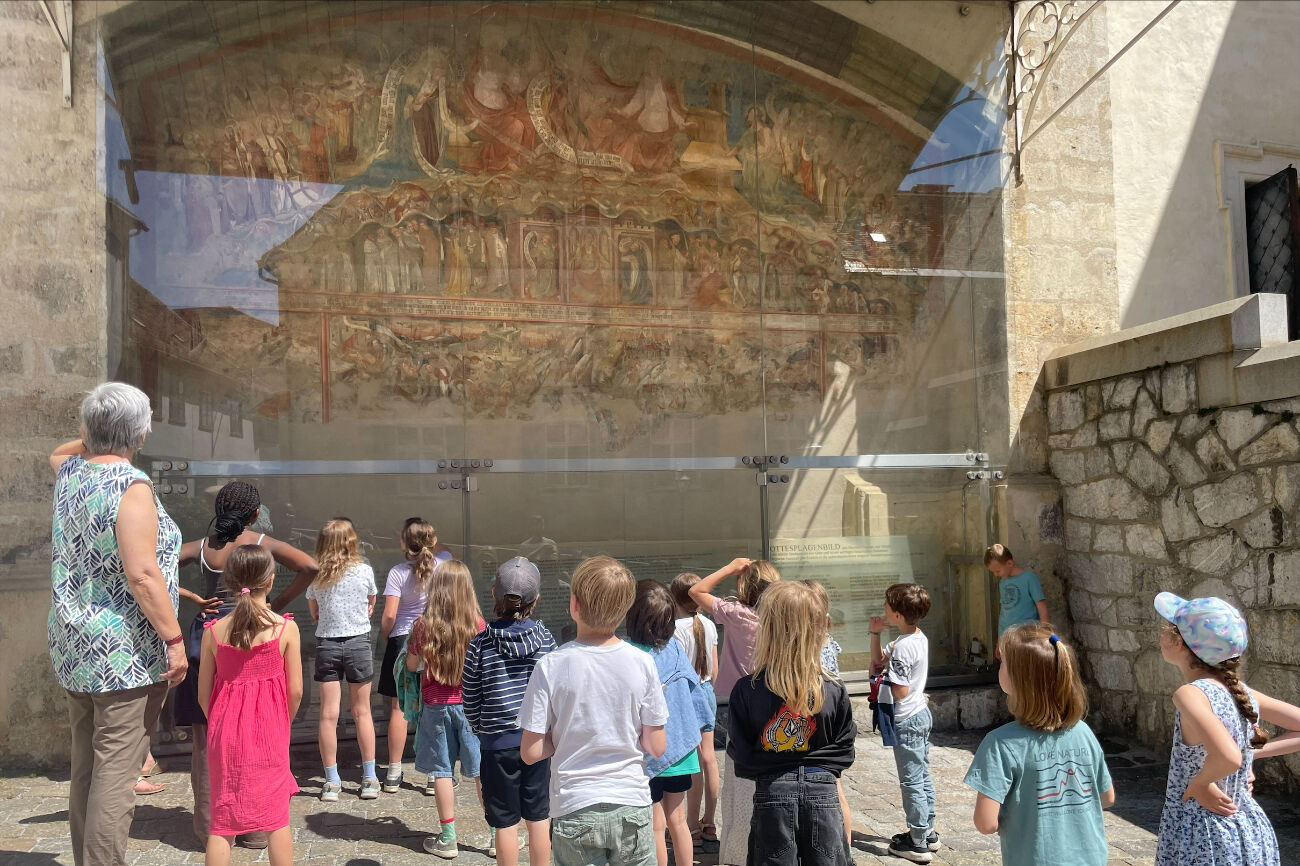 Die Kinder der Fuchs-Klasse bewundern das große Landplagenbild auf der Außenfassade des Grazer Doms.