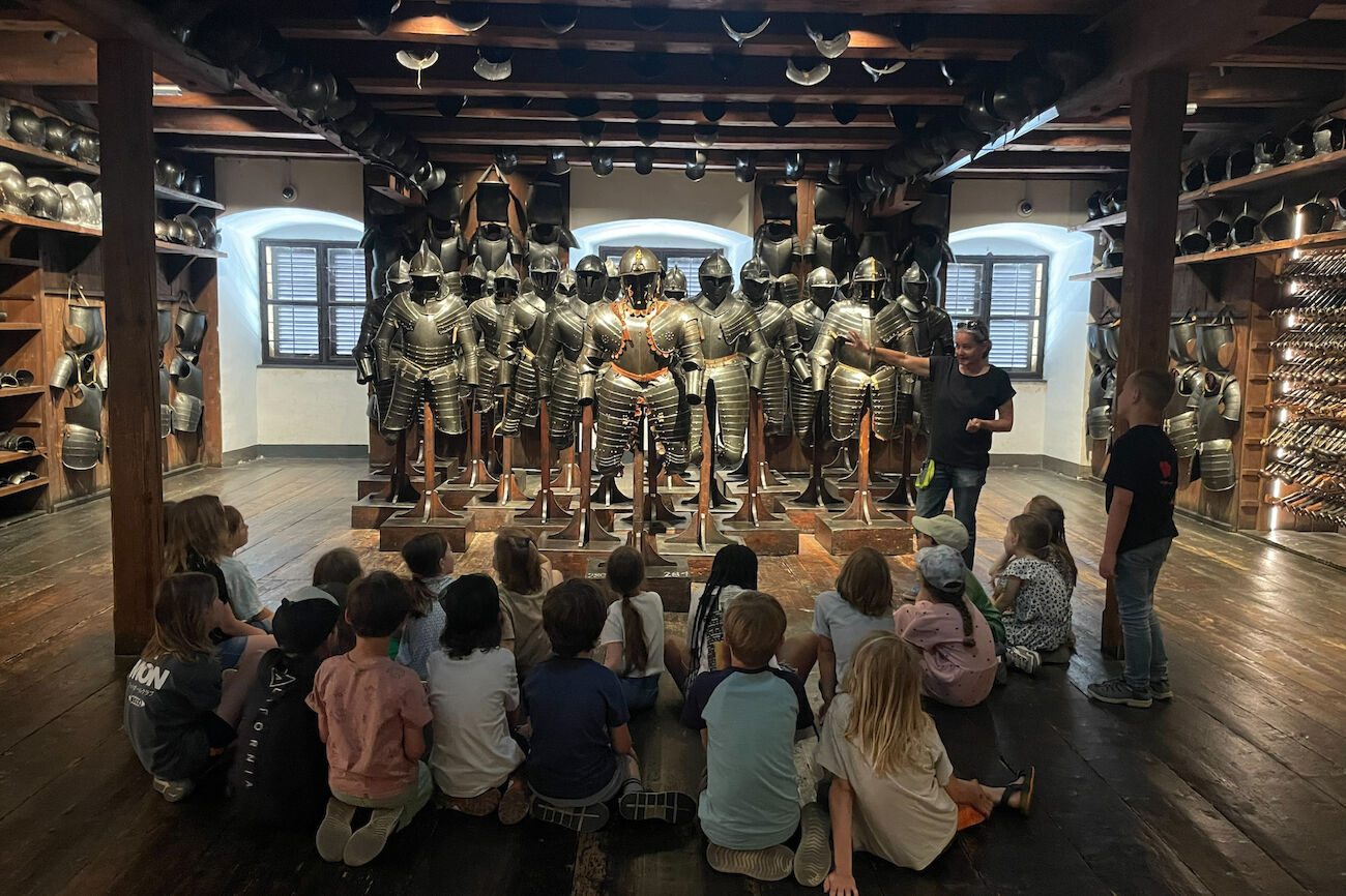 Die Kinder lauschen gespannt der Museumsführerin beim Erklären all der Rüstungsdetails zu.