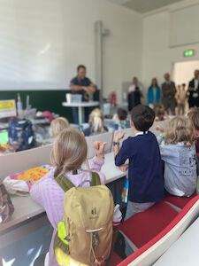 Alle Delfin-Kinder hören einem Erwachsenen seinen Ausführungen genau zu.